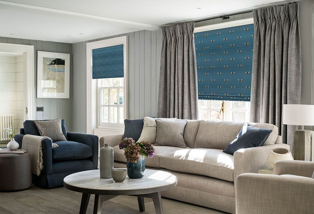 image of sofa in front of layered window with curtains and roman blind in living room