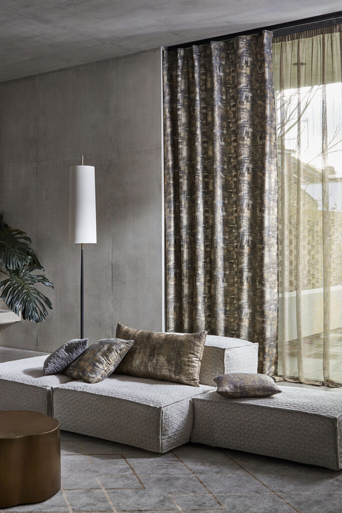 photo of a living room with a sofa in front of a large window with a sheer curtain fitted