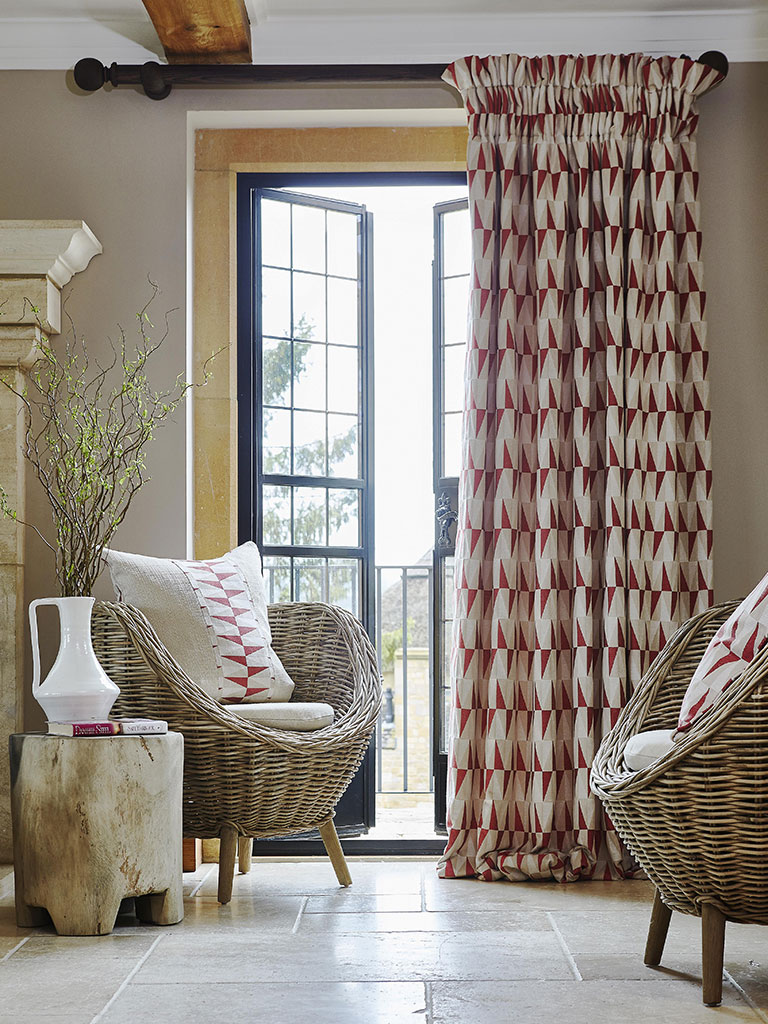 A red patterned door curtain in a living room.