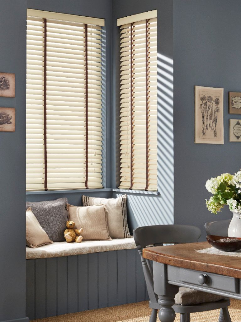 Sleek wooden blinds in a blue living room.