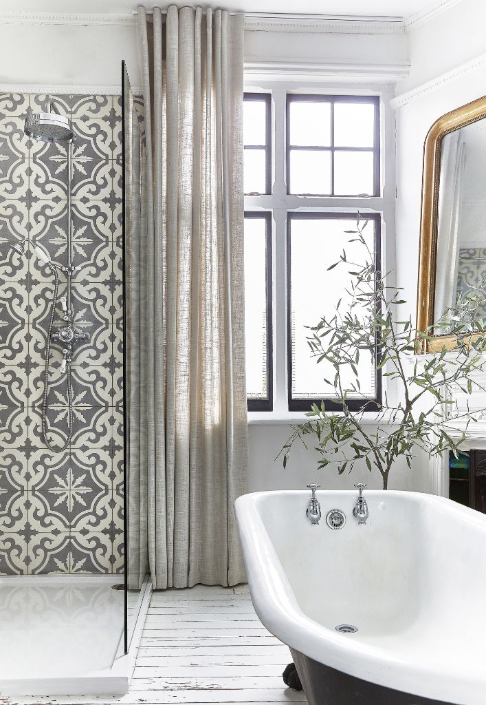 A chic spathroom with voile curtains and patterned tyles