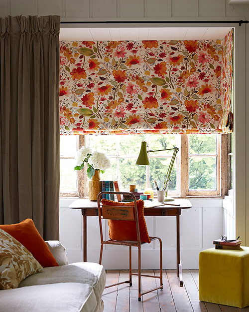 Floral roman blinds in small home office.