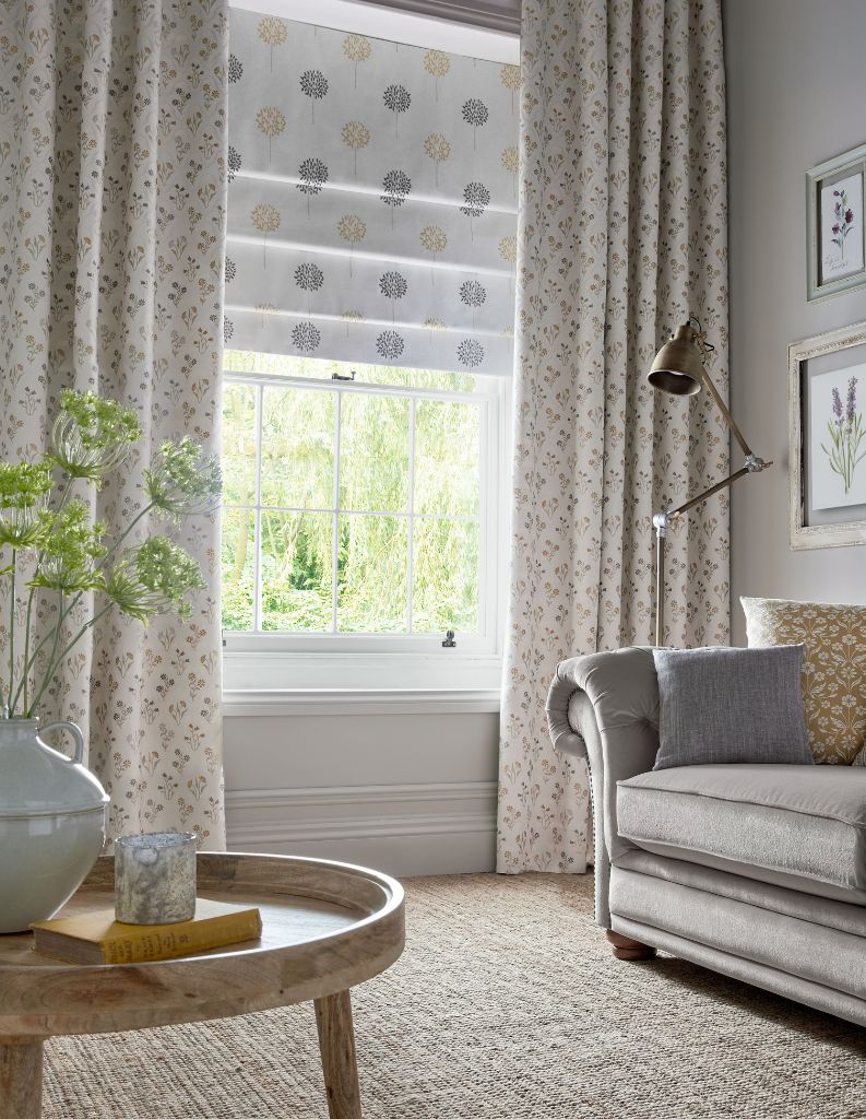 Floral blackout Roman blinds in a living room window.