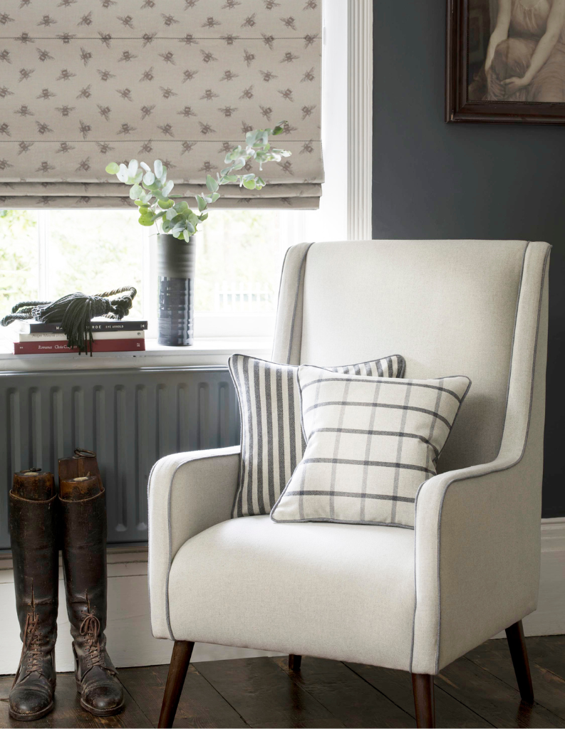 An image of bee patterned Roman blinds in a cosy sitting area.