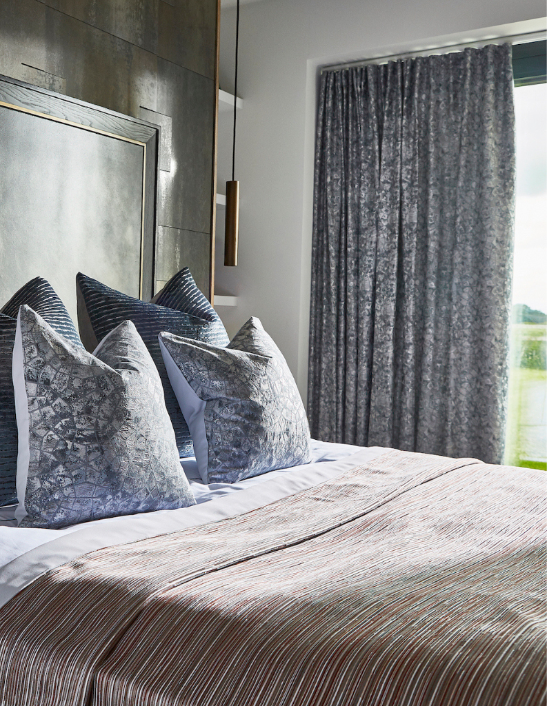 a quiet luxury inspired bedroom with comfy bed and cosy cushions.