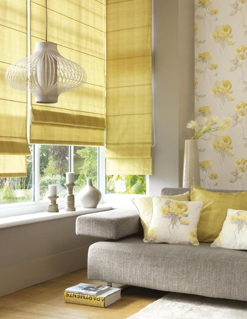 Butter yellow roman blinds in living room with sofa and matching cushions.